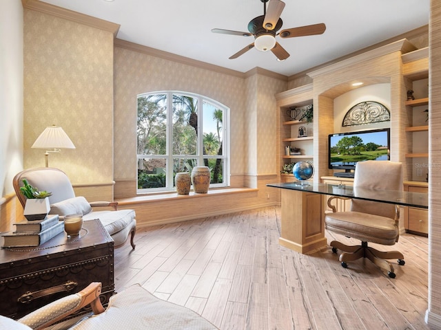 home office featuring crown molding, ceiling fan, light wood-type flooring, and built in shelves