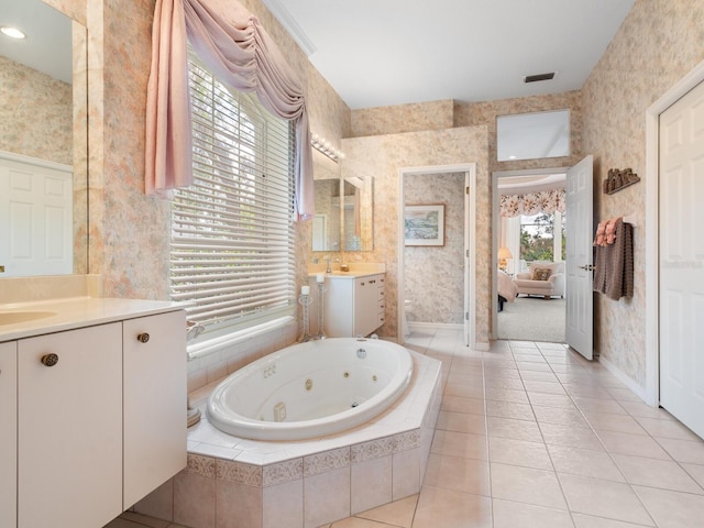 bathroom featuring vanity, tiled tub, and tile patterned flooring