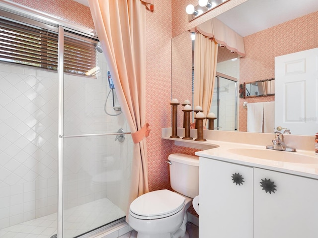 bathroom featuring toilet, vanity, and a shower with door