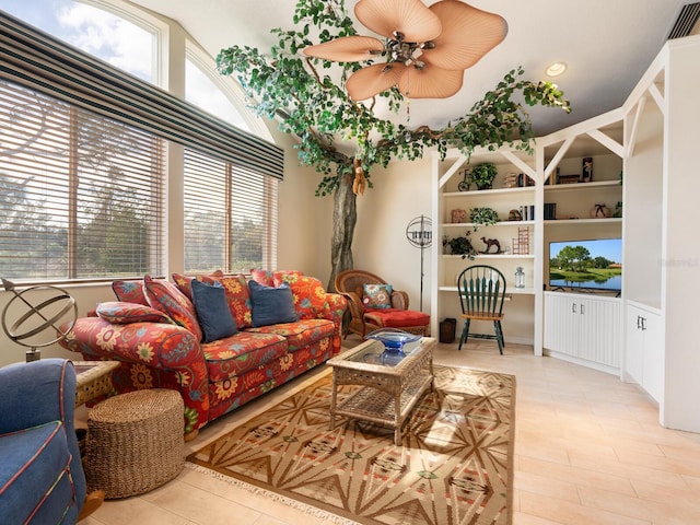 living room featuring ceiling fan and built in features