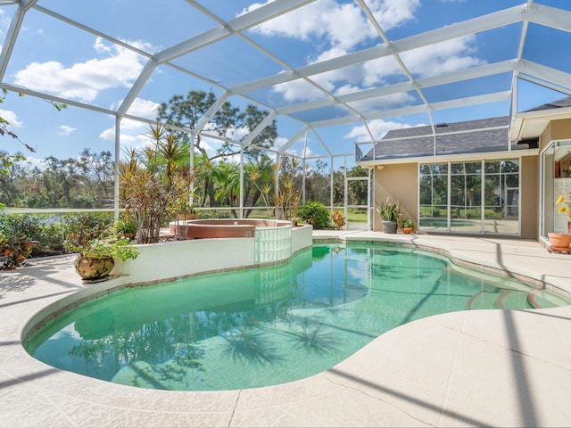 view of pool with a patio, a lanai, and an in ground hot tub