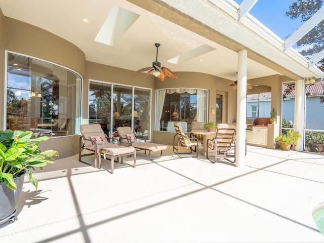 sunroom with ceiling fan, a healthy amount of sunlight, and a skylight