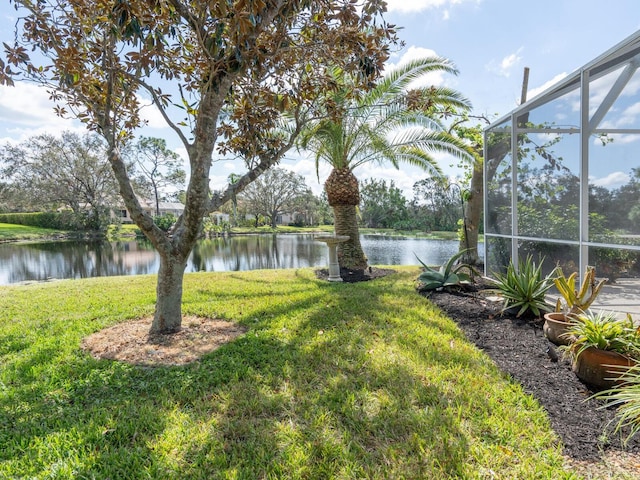 view of yard with a water view and glass enclosure