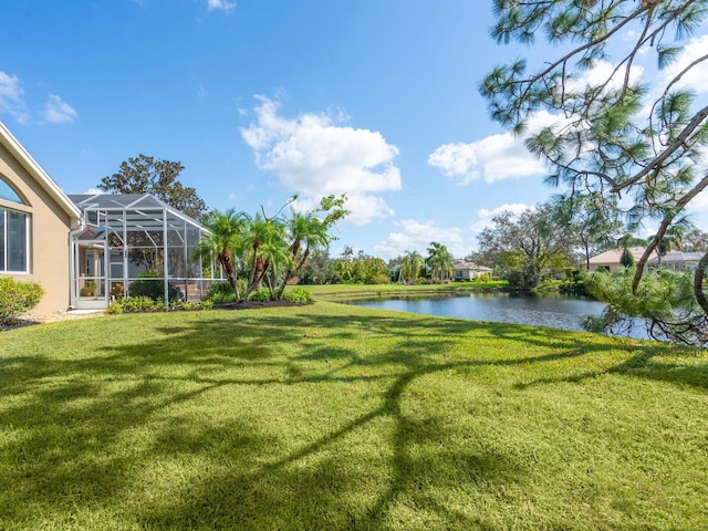 view of yard with a water view and a lanai