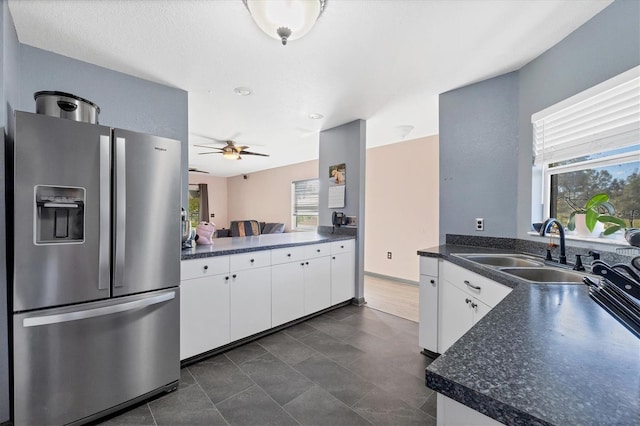 kitchen featuring white cabinets, a healthy amount of sunlight, sink, and stainless steel fridge