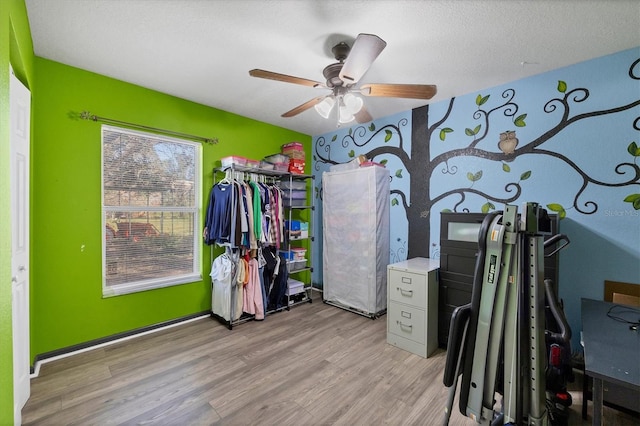 interior space featuring light hardwood / wood-style flooring, a textured ceiling, and ceiling fan