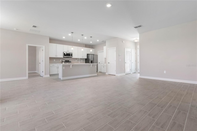 unfurnished living room with light hardwood / wood-style flooring and sink