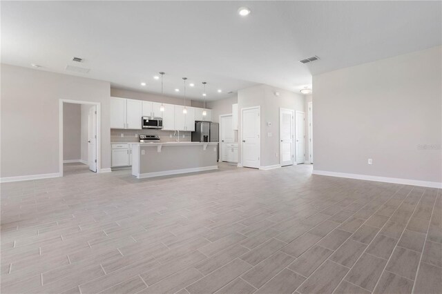 2938 Woodward Ave, North Port, FL 34286 - unfurnished living room with visible vents, recessed lighting, baseboards, and light wood-type flooring