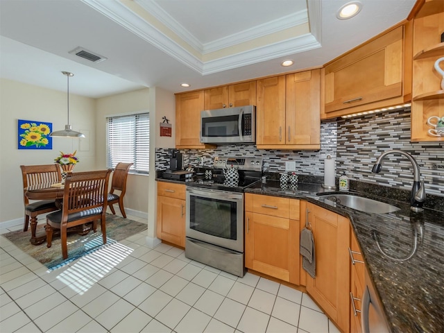 kitchen featuring tasteful backsplash, sink, stainless steel appliances, decorative light fixtures, and dark stone countertops