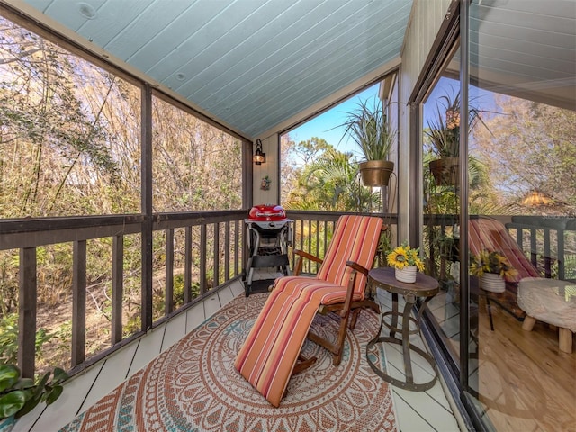 sunroom / solarium featuring a healthy amount of sunlight and vaulted ceiling