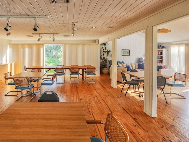 dining space with hardwood / wood-style floors, track lighting, and wooden ceiling