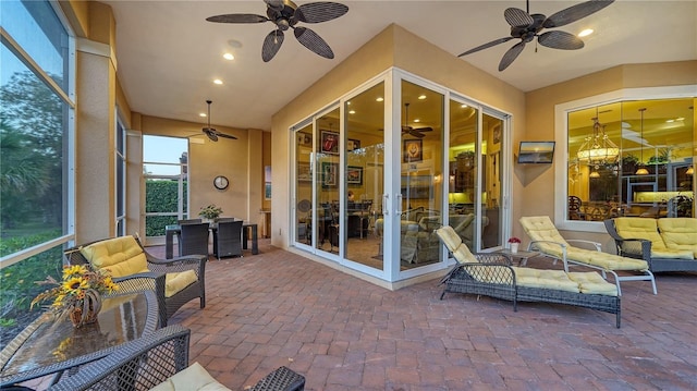 sunroom / solarium with ceiling fan with notable chandelier