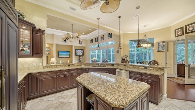 kitchen with a kitchen island, kitchen peninsula, crown molding, and light tile patterned floors