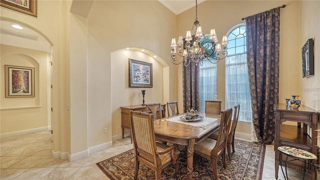 tiled dining room featuring a high ceiling and an inviting chandelier