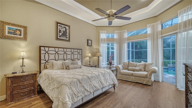 bedroom with hardwood / wood-style flooring, ceiling fan, crown molding, and multiple windows