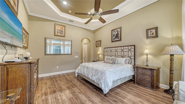 bedroom featuring wood-type flooring, ceiling fan, and crown molding