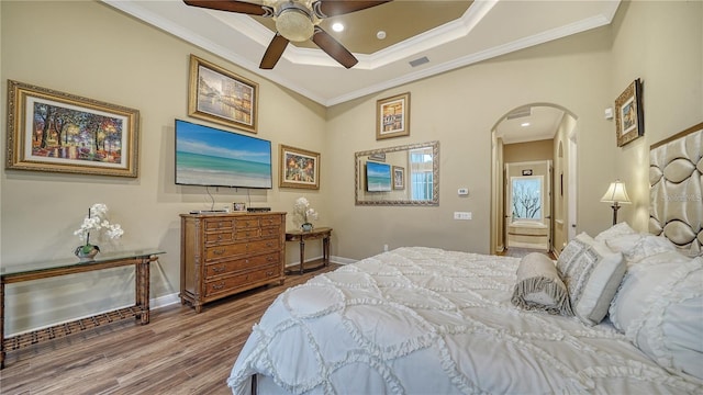 bedroom featuring hardwood / wood-style flooring, ceiling fan, and crown molding