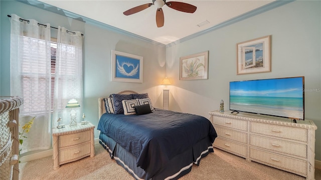 carpeted bedroom featuring ceiling fan and crown molding