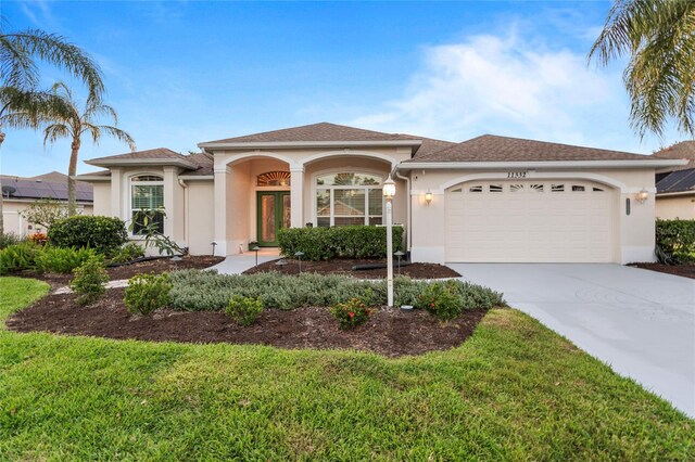 11332 Rivers Bluff Cir, Lakewood Ranch, FL 34202 - view of front of home with a garage, stucco siding, concrete driveway, and a front lawn