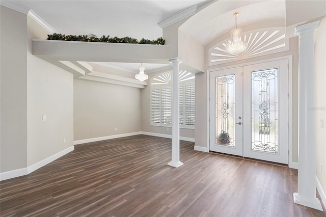 foyer entrance with a chandelier, vaulted ceiling, crown molding, and dark wood-type flooring