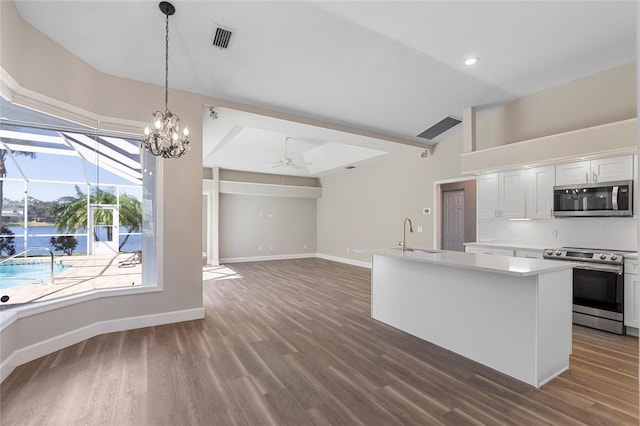 kitchen with a kitchen island with sink, ceiling fan with notable chandelier, sink, white cabinetry, and stainless steel appliances