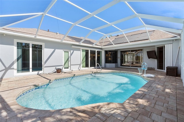 view of swimming pool with glass enclosure and a patio area