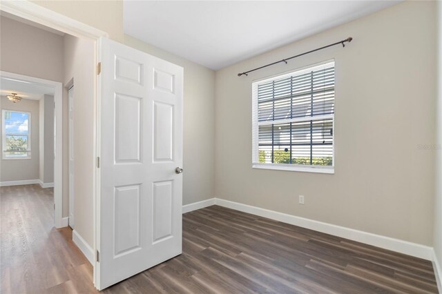 11332 Rivers Bluff Cir, Lakewood Ranch, FL 34202 - unfurnished bedroom with dark wood-type flooring, baseboards, and multiple windows