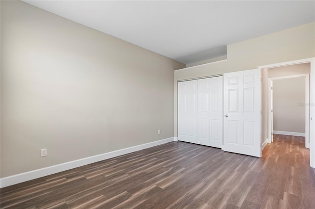 unfurnished bedroom with a closet and dark wood-type flooring