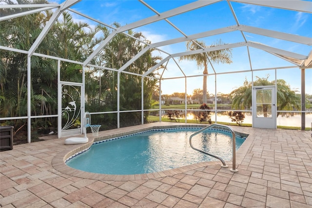 view of swimming pool with a lanai, a patio area, and a water view