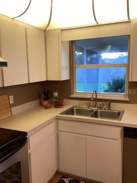 4601 Ulster Ave, North Port, FL 34287 - kitchen with light countertops, appliances with stainless steel finishes, white cabinetry, and a sink