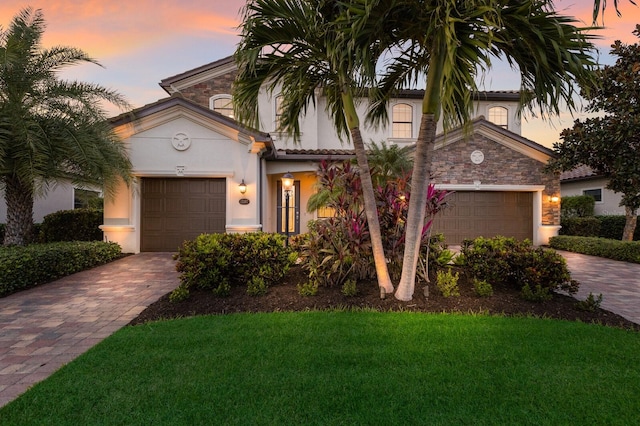 mediterranean / spanish house with a garage and a lawn