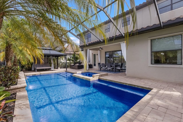 view of swimming pool with an in ground hot tub, ceiling fan, a patio area, and a gazebo