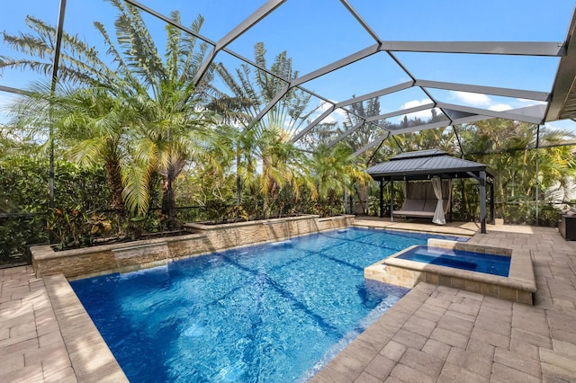 view of pool featuring a lanai, a gazebo, a patio area, pool water feature, and an in ground hot tub