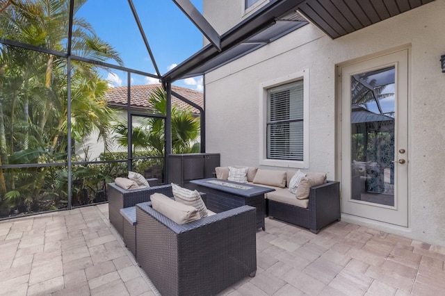 view of patio with glass enclosure and an outdoor living space with a fire pit