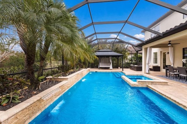 view of pool with a lanai, ceiling fan, outdoor lounge area, a patio area, and an in ground hot tub