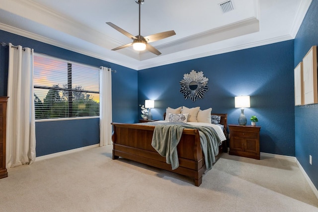 carpeted bedroom with crown molding, ceiling fan, and a raised ceiling