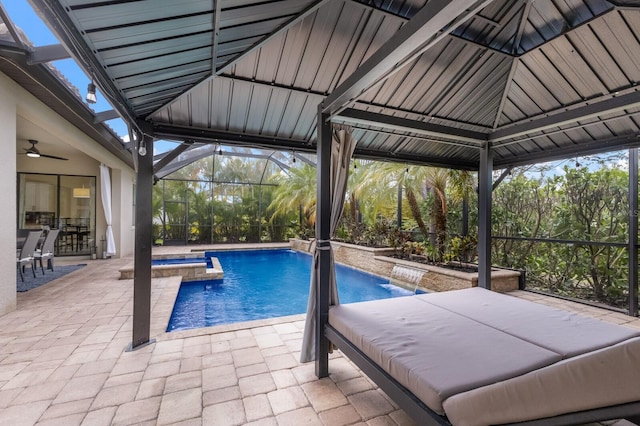 view of swimming pool featuring pool water feature, a patio area, a lanai, an in ground hot tub, and ceiling fan