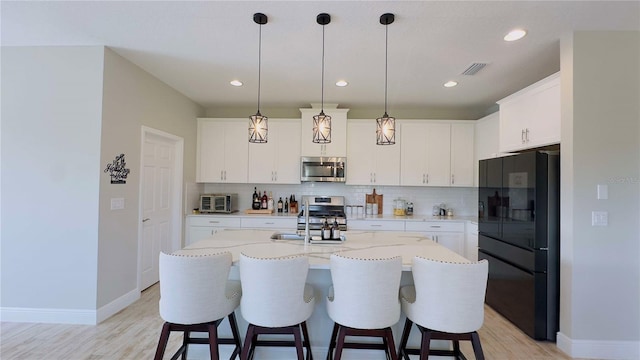 12661 Oak Hill Way, Parrish, FL 34219 - kitchen featuring appliances with stainless steel finishes, light wood-style flooring, decorative backsplash, a breakfast bar area, and recessed lighting