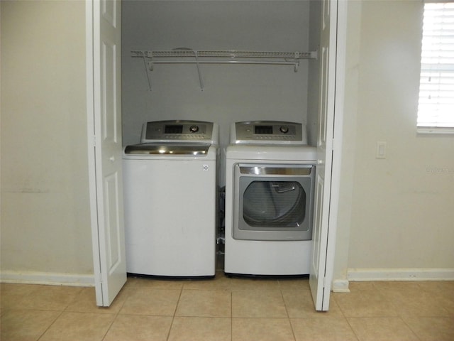 clothes washing area featuring washing machine and clothes dryer and light tile patterned floors