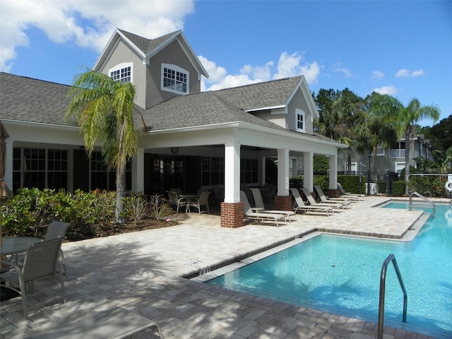 rear view of house with a community pool and a patio area