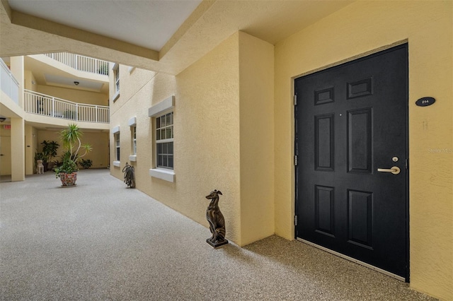 view of exterior entry with a balcony