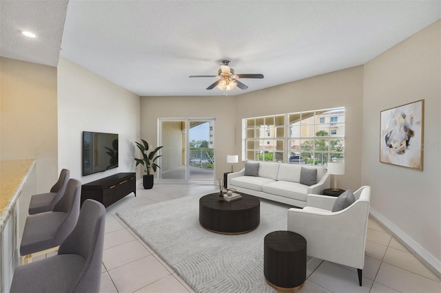 tiled living room with ceiling fan and a textured ceiling