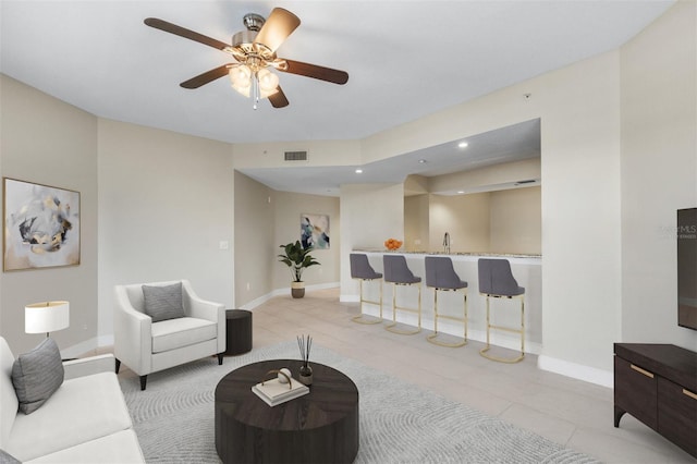 living room featuring sink, ceiling fan, and light tile patterned floors