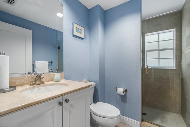 bathroom featuring vanity, toilet, and walk in shower