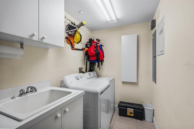 laundry area featuring sink, light tile patterned flooring, cabinets, washer and dryer, and a textured ceiling