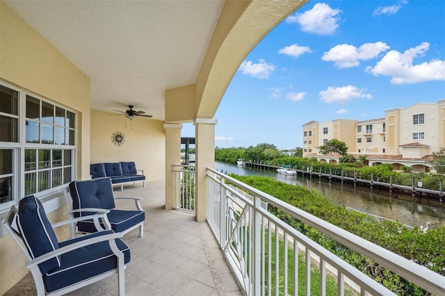 balcony featuring a water view and ceiling fan