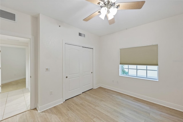 14041 Bellagio Way Unit 214, Osprey, FL 34229 - unfurnished bedroom with visible vents, light wood-style flooring, baseboards, and a closet