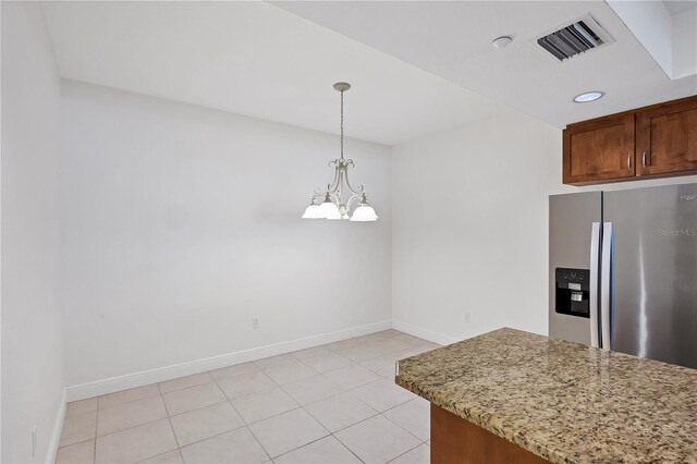 14041 Bellagio Way Unit 214, Osprey, FL 34229 - kitchen featuring visible vents, pendant lighting, stainless steel fridge with ice dispenser, baseboards, and light stone counters