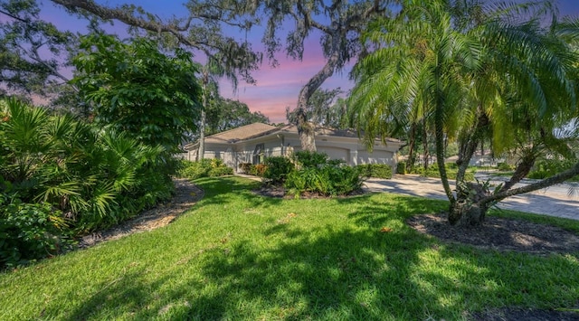 mediterranean / spanish-style house with a yard and a garage