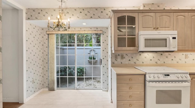 kitchen featuring a notable chandelier, light brown cabinetry, hanging light fixtures, and white appliances